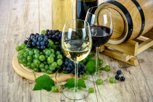 Ein Weißwein und ein Rotwein vor Weintrauben.